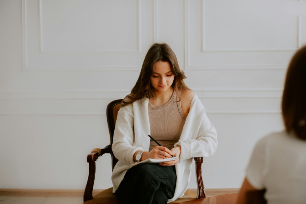 A woman taking notes during her anxiety treatment session