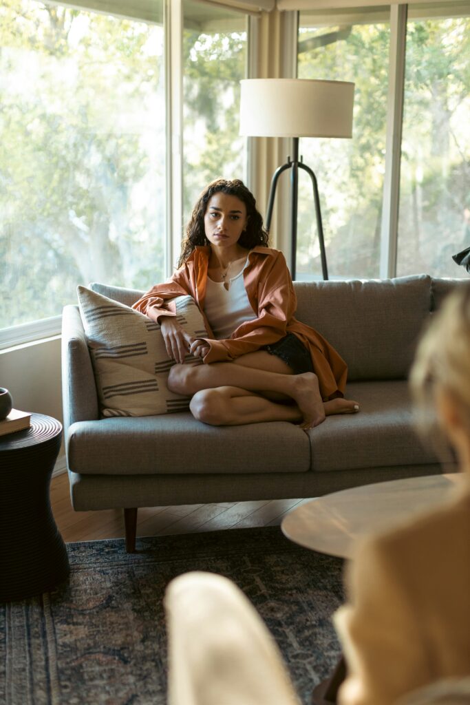A woman sitting on a couch talking to a professional about her benzo addiction