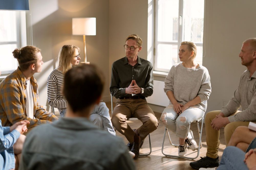 A group of people discussing alcohol addiction and trauma